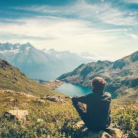 Man relaxing with serene view mountains and lake landscape