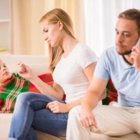 Loving parents take care of his son mother checking a temperature whilst father is phoning a doctor