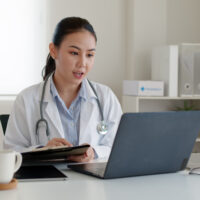 A doctor conducting telehealth while on a laptop