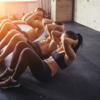 adults doing situps in a studio