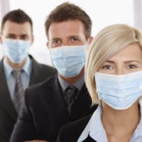 Business people fearing h1n1 swine flu virus wearing protective face mask and standing in a row
