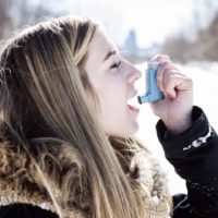 An Attractive young woman with asthma enjoying the winter outdoors
