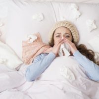Sick woman lying in bed with high fever due to the swine flu