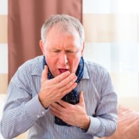 Senior gentleman violently coughing due to the whooping cough