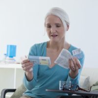 Mature lady reading the instructions to her hormone replacement therapy tablets