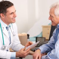 A general practitioner talking to senior man in his practice surgery