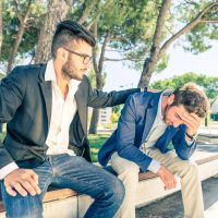 Young business man supporting a depressed friend