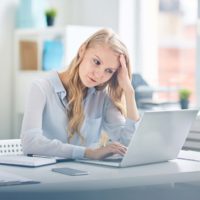 pale and tired woman working at a desk