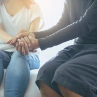 Supportive man holding woman's hand