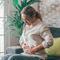 Woman holding stomach because of bloating