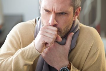 Man with whooping cough feeling sick with a scarf on
