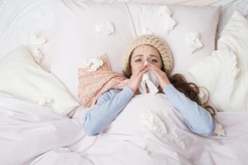Sick woman lying in bed with high fever due to the swine flu
