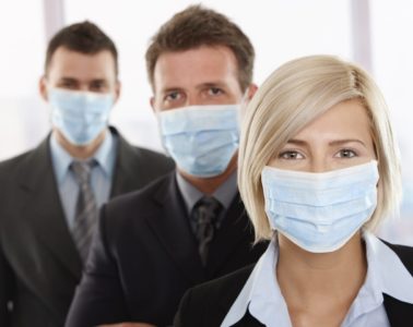 Business people fearing h1n1 swine flu virus wearing protective face mask and standing in a row
