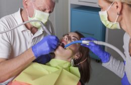 Dentist drilling into patients mouth to place an amalgam filling