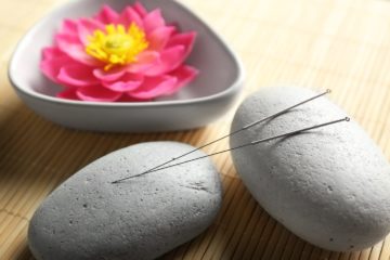 Acupuncture needles with stones on bamboo mat