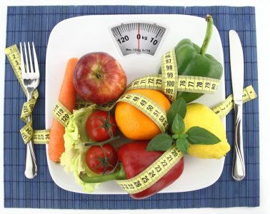 Fruits and vegetables with measuring tape on a plate as weight scale