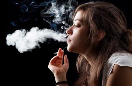 Woman Smoking a Cigarette on Black Background