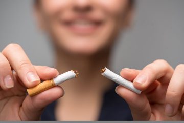 Close up portrait of young attractive woman breaking down cigarette to pieces