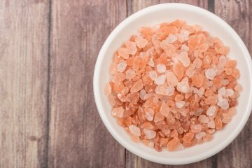 Himalayan rock salt in a bowl over wooden background