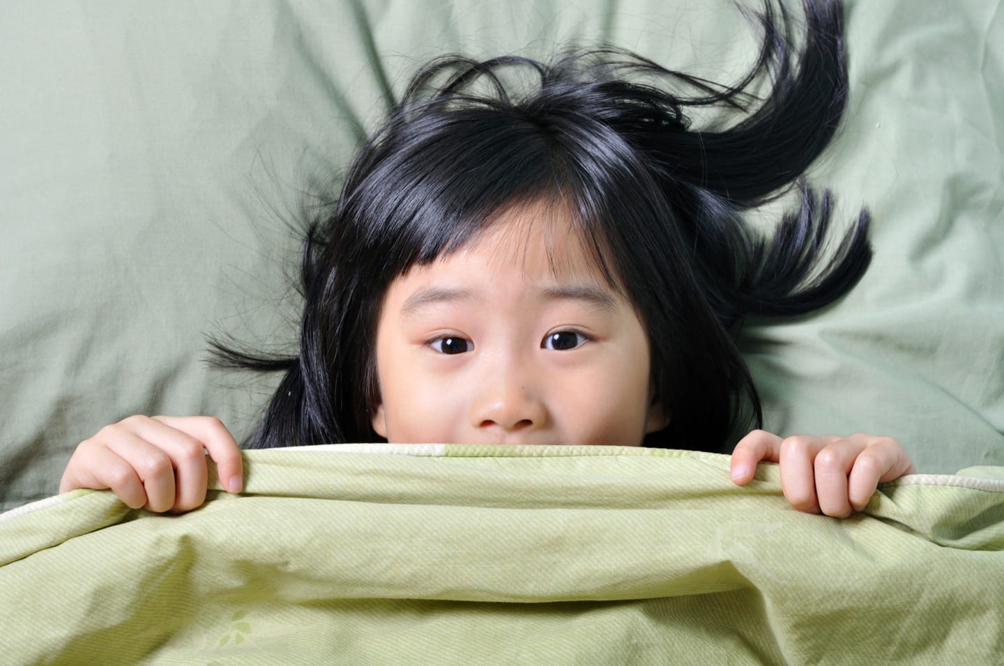 Scared-little-asian-girl-having-childhood-nightmares-and-hiding-behind-blanket.jpg