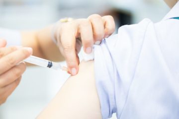 Flu vaccination being administered into the upper arm