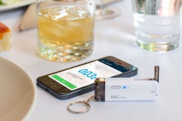 BACtrack Vio personal breathalyser on a table next to a smartphone