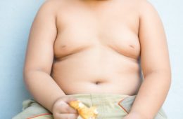 Big obese asian fay boy eating greasy unhealthy fried food