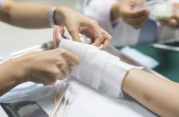 Nurse dressing wound for patients hand with burn injury