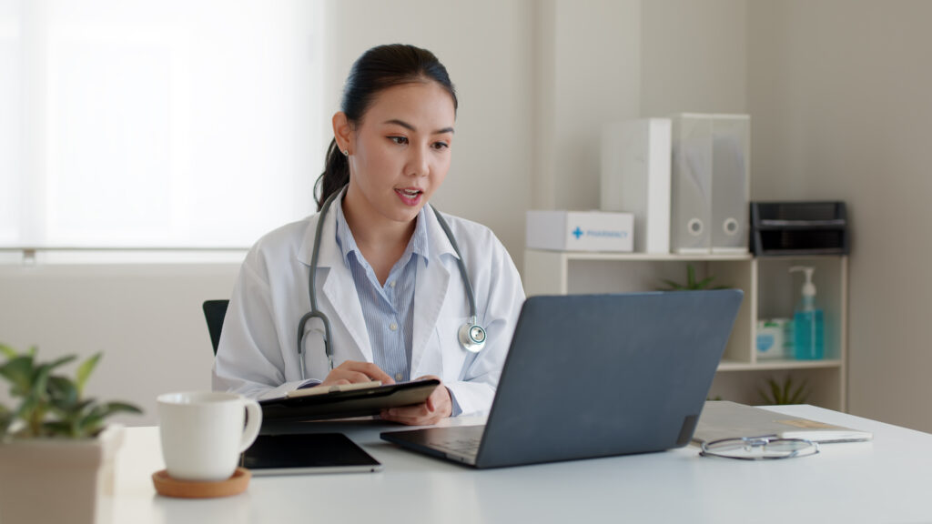 A doctor conducting telehealth while on a laptop