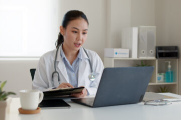 A doctor conducting telehealth while on a laptop