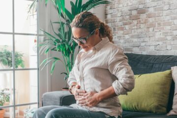 Woman holding stomach because of bloating